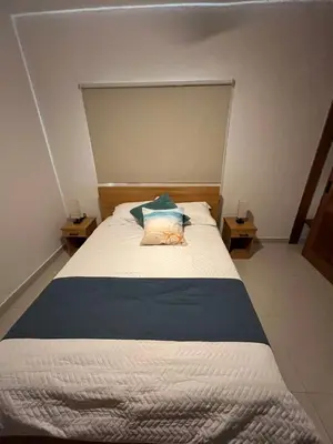 a bedroom with a bed with a blue and white blanket at GH Condos by Sunrise3 in Puerto Plata
