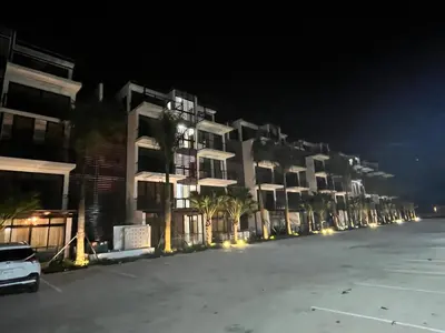 a row of apartment buildings at night with a parking lot at GH Condos by Sunrise3 in Puerto Plata