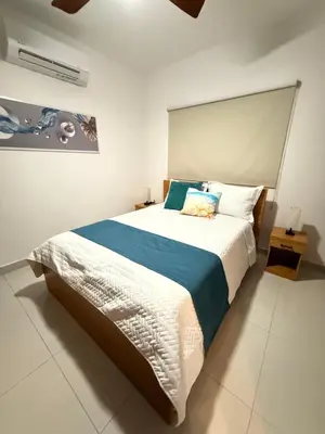 a bedroom with a large bed with blue and white sheets at GH Condos by Sunrise3 in Puerto Plata