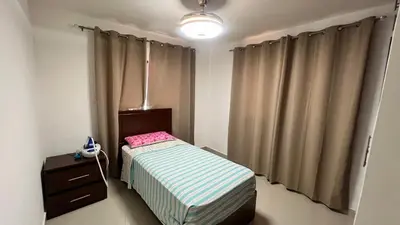 a small bedroom with a small bed and a dresser at AP Filathefia 01 in San Isidro