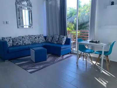 a living room with a blue couch and a table at VILLAS SONJASAA LOFt in Baní