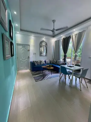 a living room with a blue couch and a table at VILLAS SONJASAA LOFt in Baní