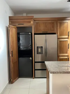 a kitchen with a refrigerator and a tv at GH Condos by Sunrise2 in San Felipe de Puerto Plata