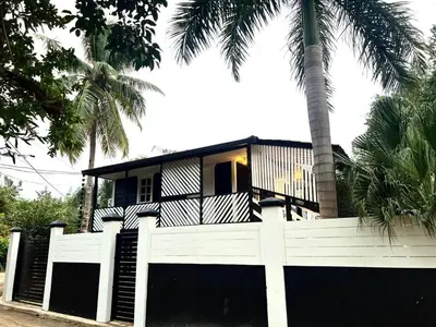 a house with a white fence and palm trees at Santa's Villa Punta Rucia in Punta Rucia