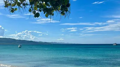 a view of the ocean with boats in the water at Santa's Villa Punta Rucia in Punta Rucia