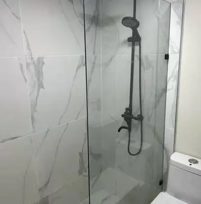 a shower with a glass door next to a toilet at Solano Apartamentos in Boca Chica