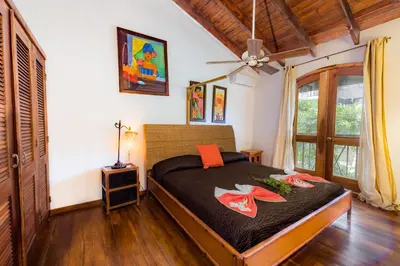 a bedroom with a bed with red shoes on it at Penthouse beach front in Las Terrenas