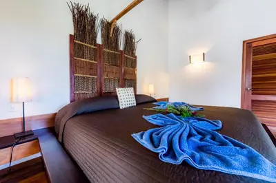 a bedroom with a bed with a blue blanket on it at Penthouse beach front in Las Terrenas