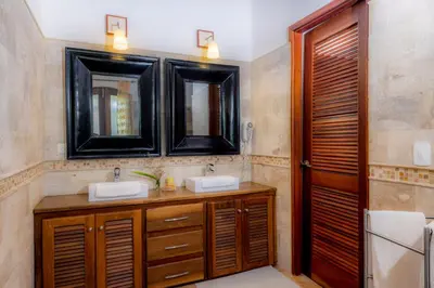 a bathroom with two sinks and two mirrors at Penthouse beach front in Las Terrenas