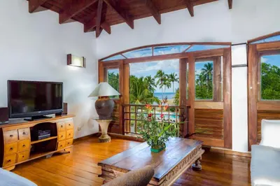 a living room with a tv and a table with a couch at Penthouse beach front in Las Terrenas