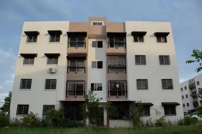 a tall white building with black windows at Apartamento tranquilo y cómodo in La Javilla