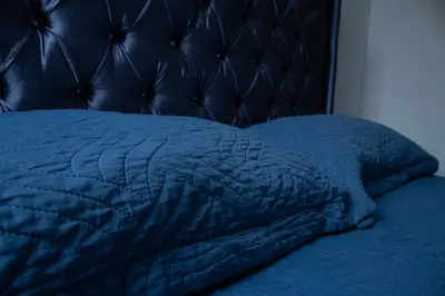 a close up of a bed with a blue blanket at Apartamento tranquilo y cómodo in La Javilla