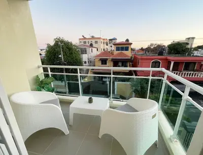 a balcony with white chairs and a view of a city at 3 bedroom apartment with private jacuzzi and terrace in Ensanche Savica de Mendoza