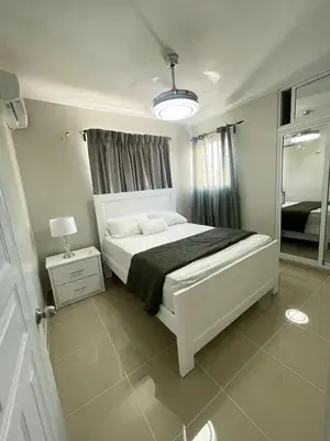 a bedroom with a white bed and a mirror at 3 bedroom apartment with private jacuzzi and terrace in Ensanche Savica de Mendoza