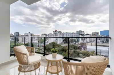 a balcony with chairs and a view of a city at Luxury apt city views in the center of the city in Santo Domingo