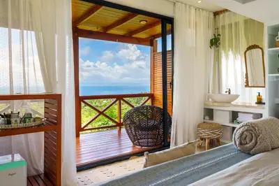 a bedroom with a balcony with a view of the ocean at Araya Resort in Las Galeras