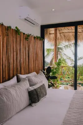 a bedroom with a white bed with a large window at Araya Resort in Las Galeras