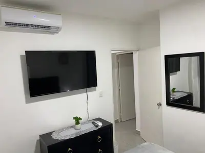 a living room with a flat screen tv on a wall at Apartamento en Higuey City Home in Higuey