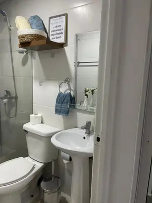 a white bathroom with a toilet and a sink at Apartamento en Higuey City Home in Higuey