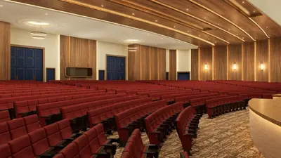 an empty auditorium with red chairs and a tv at Moon Palace The Grand Punta Cana in Punta Cana
