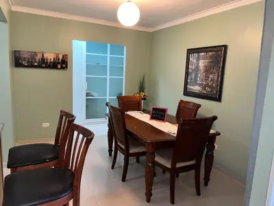 a dining room with a table with chairs and a laptop on it at Tranquilo Apartamento de 3 habitaciones in Los Paredones
