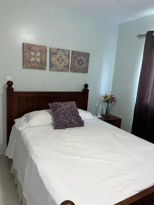 a bedroom with a white bed with two pictures on the wall at Tranquilo Apartamento de 3 habitaciones in Los Paredones