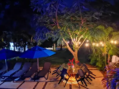 a patio with a table and chairs and blue umbrellas at Villa Victoria in Sosúa