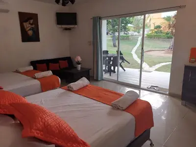 two beds in a room with a view of a patio at Villa Victoria in Sosúa