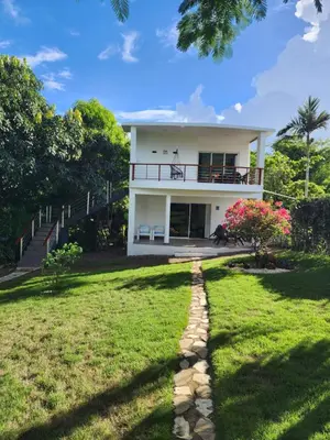 a white house with a pathway leading to a yard at Villa Victoria in Sosúa