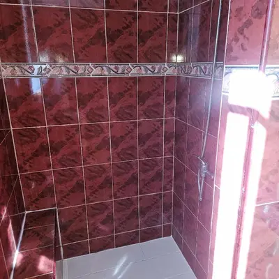 a bathroom with a red tiled shower with a light at Villa del sol in Infiernito