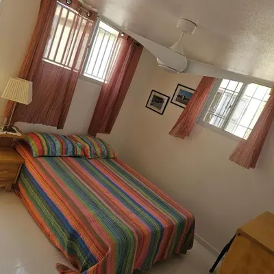a bedroom with a bed with a colorful striped comforter at Villa del sol in Infiernito