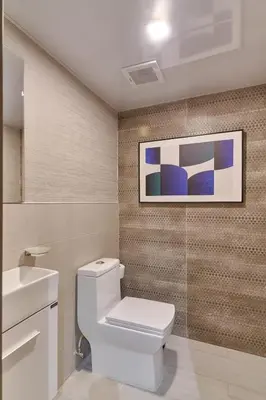 a bathroom with a toilet and a picture on the wall at Modern Comfort Apartment at Bella Vista in Santo Domingo