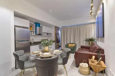 a kitchen and living room with a table and chairs at Modern Comfort Apartment at Bella Vista in Santo Domingo