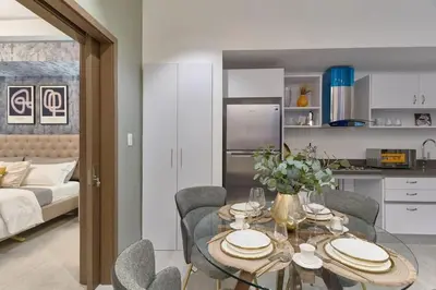 a kitchen and living room with a table and chairs at Modern Comfort Apartment at Bella Vista in Santo Domingo