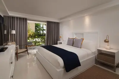 a white bedroom with a large bed and a window at The Ocean Club, a Luxury Collection Resort, Costa Norte in Sosúa