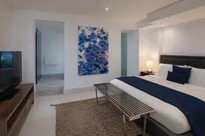a bedroom with a large bed and a television at The Ocean Club, a Luxury Collection Resort, Costa Norte in Sosúa