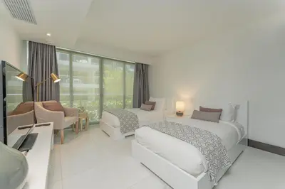 a white bedroom with two beds and a couch at The Ocean Club, a Luxury Collection Resort, Costa Norte in Sosúa