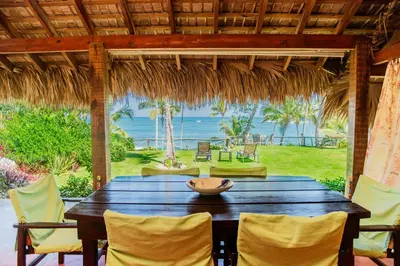 a table with chairs and a view of the ocean at Villa Caribeña in Las Galeras