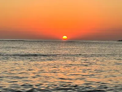 a sunset over the ocean with the sun setting at Villa Guavaberry in Juan Dolio