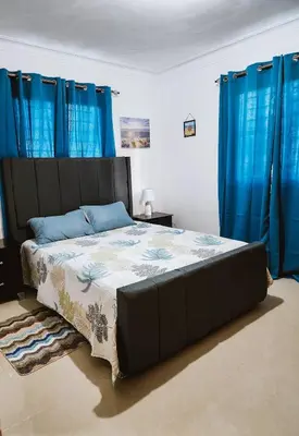 a bedroom with a large bed with blue curtains at Cozy apartment Marea Azul in La Francia