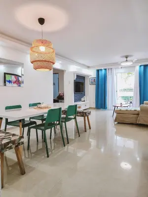a living room with a table and green chairs at Cozy apartment Marea Azul in La Francia