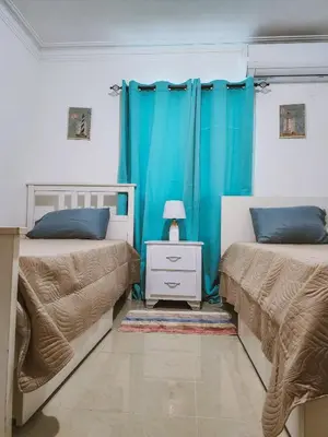 a bedroom with two beds and a blue curtain at Cozy apartment Marea Azul in La Francia