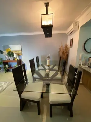 a glass dining room table with two chairs and a lamp at Cozy retreat with luxurious feel in Santiago de los Caballeros