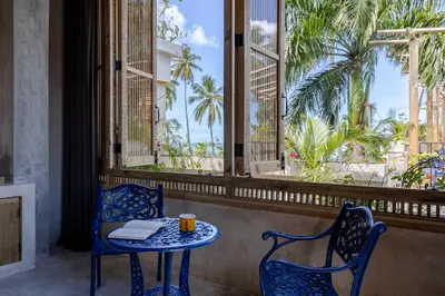 a table and chairs in a room with palm trees at El Mambo Boutique Hotel in Las Terrenas