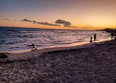 a group of people on the beach at sunset at Beautiful Accommodation in La Romana Beach View in La Romana