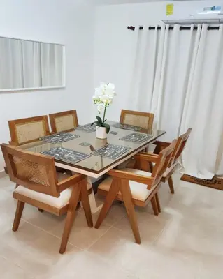 a dining room table with chairs and a vase with flowers at Beautiful Accommodation in La Romana Beach View in La Romana