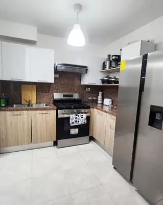 a kitchen with a stainless steel refrigerator and a stove at Beautiful Accommodation in La Romana Beach View in La Romana