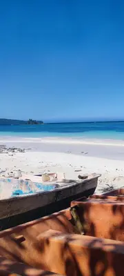 a boat on a beach with the ocean in the background at MOREHomes - Caribe Slow Cost in Las Galeras