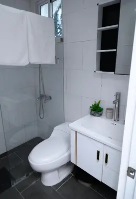 a white bathroom with a toilet and a sink at villas ecologicas hacienda vista linda in Cabrera