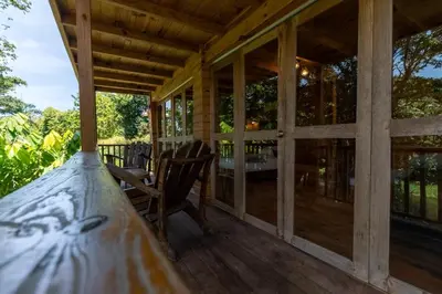 a screened in porch with a table and a chair at villas ecologicas hacienda vista linda in Cabrera